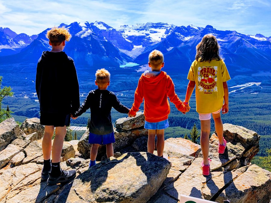 Dr. Graham's four children holding hands at Banff National Park overlooking Lake Louise